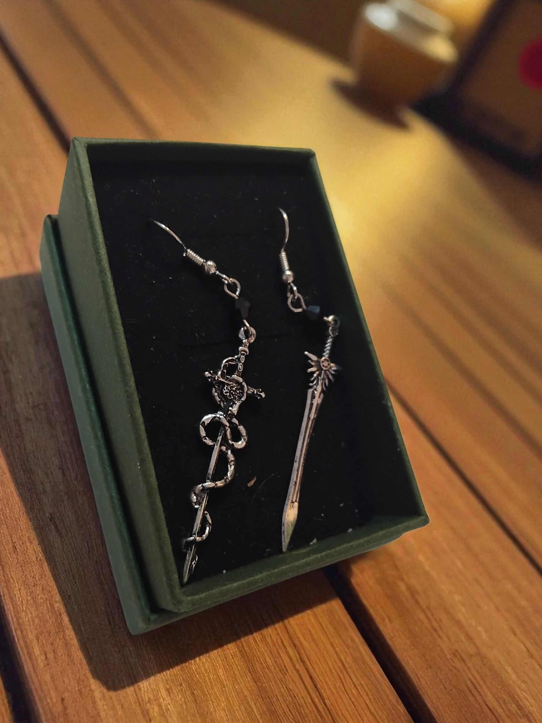 (E16) Mismatching Goth snake and sword earrings
